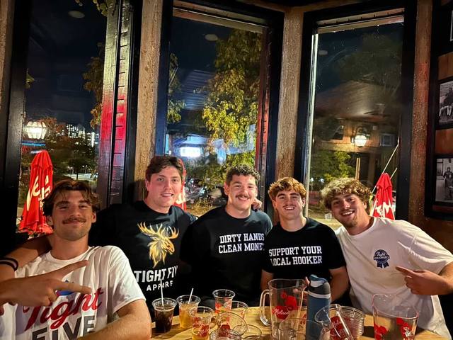 Customers in Tight Five tees at the bar